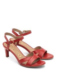 Czerwone skórzane sandały z niskim obcasem, z krzyżującymi się paskami i regulowanym paskiem na kostkę. Wnętrze ma brązowe, teksturowane wykończenie.