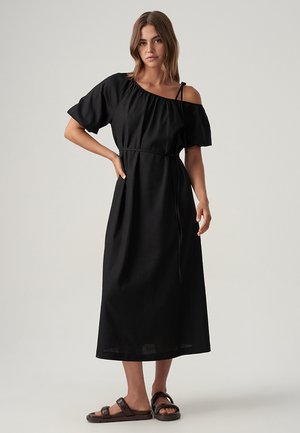 Sort off-shoulder kjole med korte ærmer, taljebind og flydende silhuet. Glat tekstur, ankellængde og afslappet pasform.