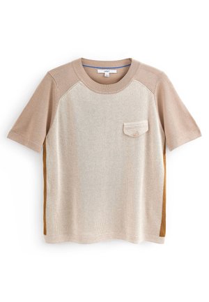 Short-sleeve beige knit top with contrasting sleeves, a small buttoned chest pocket, and darker side panels.