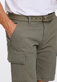 Olivgröna cargoshorts med en slät tygkvalitet, med en sidficka och ett vävt bälte med metall detaljer och hål.