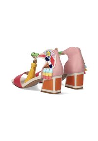 Sandalias rosas y rojas con tacón cuadrado. Presentan un diseño de pájaro con decoraciones coloridas y un borlón amarillo. Material de cuero.