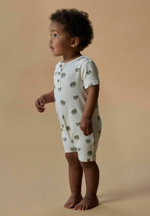 Rompers à manches courtes, de couleur crème avec des motifs floraux verts, fermeture à boutons et jambes côtelées, conçus pour le confort et la liberté de mouvement.