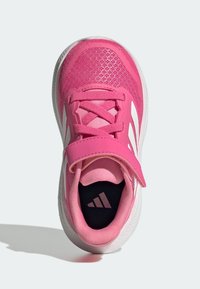 Baskets de sport roses avec tige en mesh, sangle réglable et accents blancs. Bout arrondi et semelle texturée pour traction. Logo Adidas visible à l'intérieur.