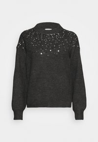 Pull en tricot gris foncé à manches longues et col haut, décoré de paillettes noires et argentées dispersées sur le haut de la poitrine et les épaules.