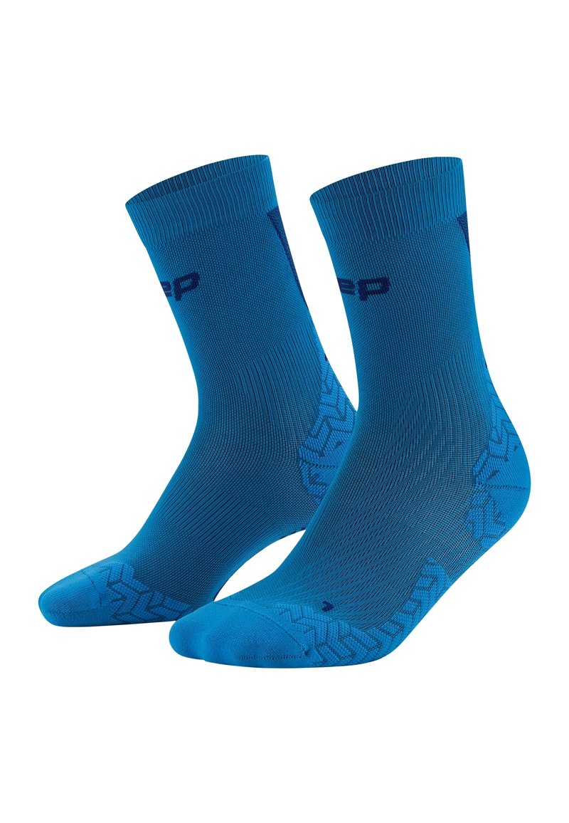 Calze sportive blu con bordo a coste, motivo antiscivolo sul fondo e dettaglio logo vicino alla parte superiore. Realizzate in materiale traspirante.