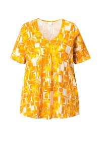 T-shirt à manches courtes en V de couleur jaune et blanche, arborant un motif géométrique abstrait avec des formes et des textures variées sur un tissu léger.