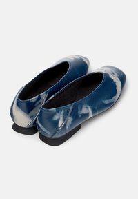 Zapatos planos de cuero azul con patrones únicos en forma de nube, que presentan un tacón bajo y un diseño de punta redondeada.