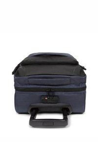 Maleta de viaje de tejido navy con parte superior negra, dos cremalleras, asa plana y exterior texturizado. Diseño rectangular compacto para viajar.