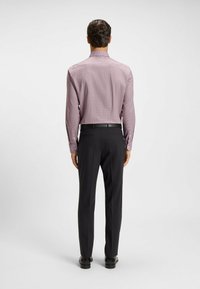 Chemise à manches longues, ajustée, à carreaux lilas clair associée à un pantalon noir sur mesure. Tissu lisse, design minimaliste et poignets à boutons.
