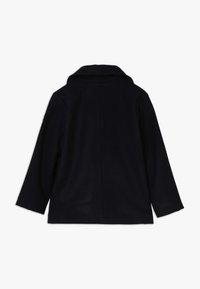 Námořnická modrá vlněná bunda s dlouhými rukávy a skládaným límcem, zobrazená zezadu na čistém bílém pozadí.