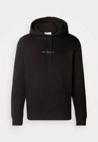Sweat à capuche noir avec cordons à l'avant et logo subtil Calvin Klein Jeans brodé sur la poitrine.