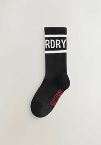 Juodos kojinės su baltomis horizontaliomis juostelėmis, ant kurių yra užrašas "RDRY." Žodis "SUPERDRY" raudonai atspausdintas šone.