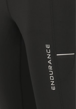 Leggings noirs en matériau extensible, avec un logo blanc "ENDURANCE", une petite poche et des coutures contrastantes le long des coutures.
