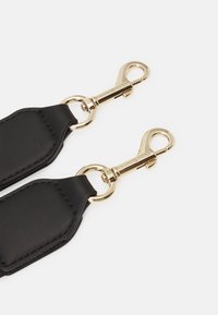 Black leather strap with gold metal clasps, featuring a smooth texture and rectangular shape, with stitching detail along the edges.