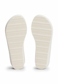Witte rubberen schoenzolen met horizontale groeven en het reliëf logo "TOMMY HILFIGER". Glad oppervlak, afgeronde randen en een lichte contour voor ondersteuning.