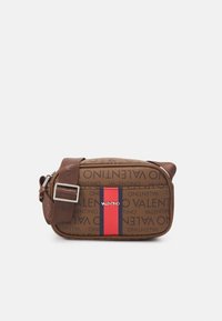 Brown Valentino crossbody bag with repeated logo print, adjustable strap, and red and navy vertical stripe on front pocket.