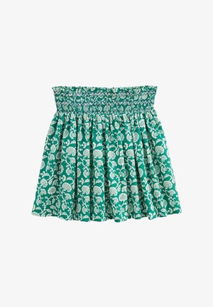 Jupe verte à motif floral avec taille smockée, présentant un design plissé et des motifs botaniques blancs sur tout le tissu.