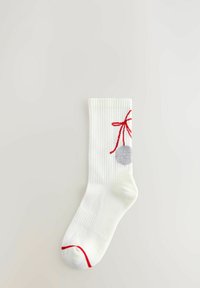 Hvid ankelstrømpe med rød kant på tæerne og et rød sløjfedesign, der holder en grå pom-pom nær den øverste kant på en ensfarvet baggrund.