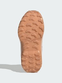 Shoe sole with textured rubber, featuring a light peach color, deep treads, and a zigzag pattern for traction.