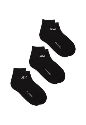 Trīs melnu potīšu zeķu pāri ar baltu "Karl" parakstu un "Karl Lagerfeld" tekstu uz baltas fona.