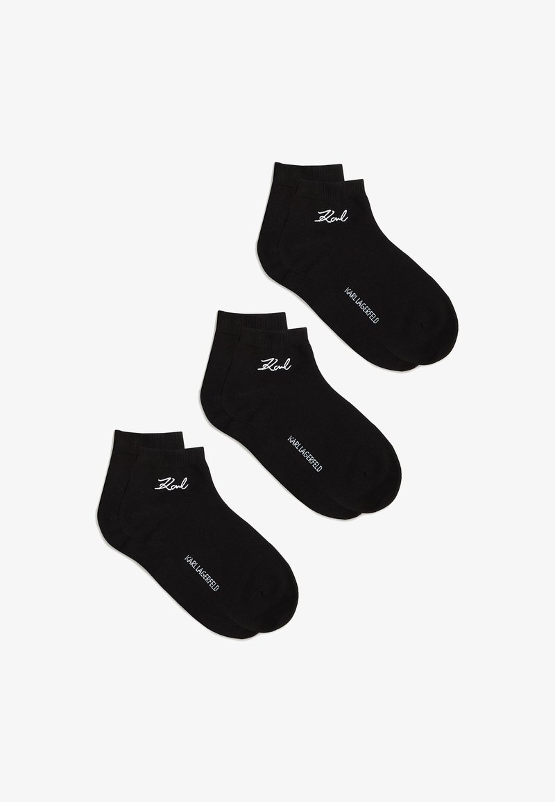 Trīs melnu potīšu zeķu pāri ar baltu "Karl" parakstu un "Karl Lagerfeld" tekstu uz baltas fona.