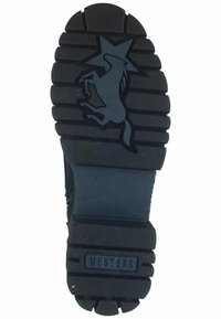 Suela de zapato de goma negra con surcos profundos, un unicornio con un logo de estrella, y "MUSTANG" grabado cerca del talón. Tamaño 37 indicado.