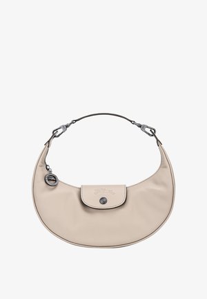 Beige leather shoulder bag with a curved shape, featuring a flat flap closure, silver hardware, and a keychain accent. Smooth texture.