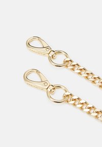 Kultaketju, jossa on kaksi hummerilukkoa. Linkit ovat sileäpintaisia ja kiiltäviä. Jokaisessa lukossa on pyöreä renkaallinen liitäntä.