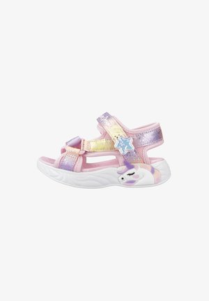 Sandálias infantis cor-de-rosa e roxas com fechos de velcro, um upper brilhante e um design de unicórnio na lateral. Sola branca texturizada para conforto.