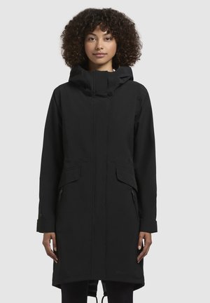 Parka noir imperméable avec capuche, dotée de deux poches frontales, d'un ourlet ajustable à cordon de serrage, et d'un design minimaliste. Texture lisse.