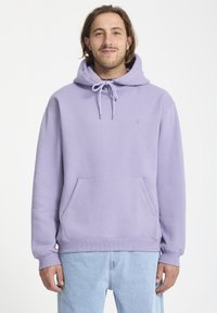 Haut à capuche violet en tissu doux, avec une poche avant, un cordon de serrage à la capuche et des poignets et un ourlet côtelés. Détail de logo simple sur la poitrine.