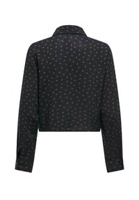 Chemise noire à manches longues, cropped, avec un col, ornée d'un petit motif de nœuds roses sur l'ensemble du tissu.