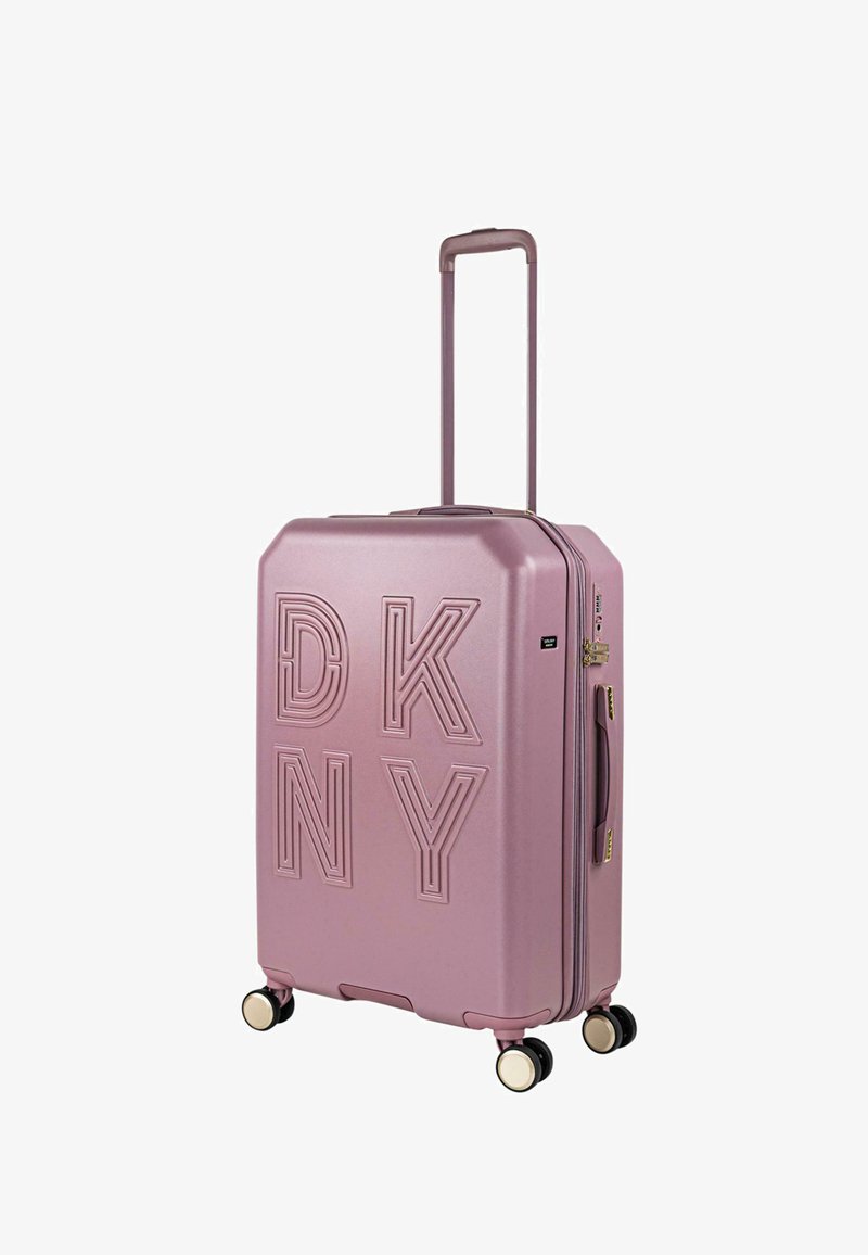 Maleta rígida DKNY en color rosa claro mate con logo en relieve, esquinas redondeadas, asa retráctil y cuatro ruedas dobles.