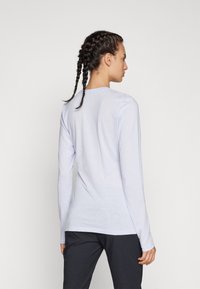 Šviesiai mėlynas ilgomis rankovėmis marškinėliai, pagaminti iš minkštos medžiagos, su apvaliu iškirpimu. Išskirtinė slim fit forma ir subtilūs siuvimo akcentai nugarinėje pusėje.