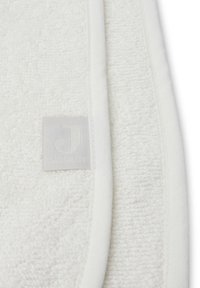 Witte handdoek gemaakt van textuurstof met een zachte, pluche oppervlak. Heeft een gestikt rand en een rechthoekig label met de opdruk "J."