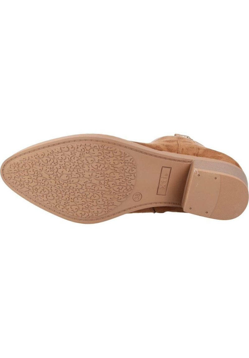 Suela de bota de ante de color beige con un dibujo texturizado y en patrón. Forma redondeada y tacón modesto con una suela lisa. Logotipo de la marca grabado cerca del tacón.