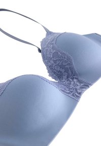 Reggiseno azzurro chiaro con tessuto liscio e dettagli in pizzo sul bordo superiore, dotato di spalline regolabili su uno sfondo bianco.