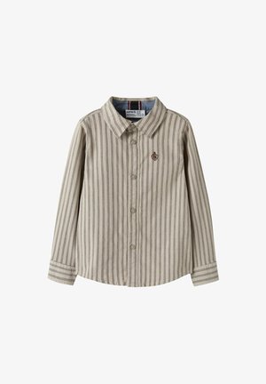 Beige langermet skjorte med knapper og tynne vertikale striper, samt et lite brodert emblem på venstre bryst.