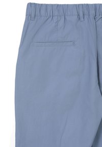 Helle blaue Hose mit einem elastischen Bund, Gürtelschlaufen und einer einzelnen paspelierten Gesäßtasche auf der rechten Seite.