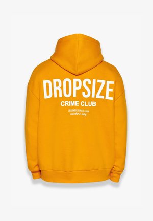 Sweatshirt à capuche jaune avec un texte blanc au dos : "DROPSIZE CRIME CLUB," "LÉGENDES DEPUIS 2020," et "réservé aux membres." Tissu doux, coupe décontractée.