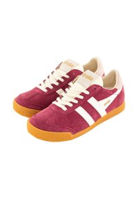 Red suede sneakers with white stripes and a tan rubber sole. Gold logo on the tongue. Low profile with lace-up design and textured sole.