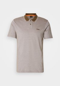 Polo gris avec un col marron et des rayures blanches, patte de boutonnage à deux boutons et un petit logo marron sur la poitrine. Manches courtes.