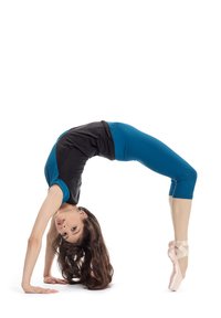 Ballet dancer in a black and blue fitted outfit, performing a backbend on stage, wearing pink pointe shoes with crossed ribbons.