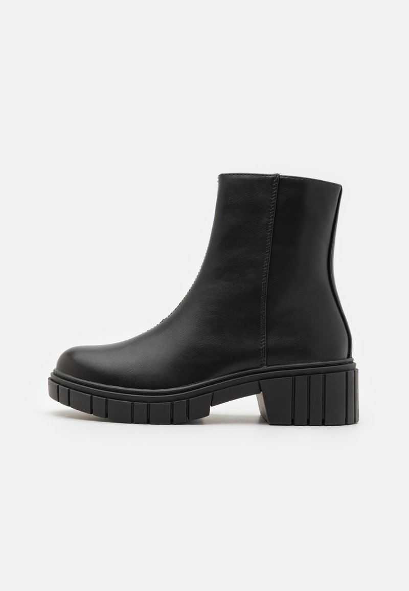Bottines noires en cuir lisse avec un talon bloc et une semelle épaisse et crantée. Présente un design simple et sans couture, avec une fermeture éclair sur le côté.