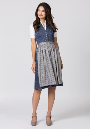 Traditionelles Outfit mit einem dunkelblauen Mieder, weißem Hemd und grauem gemustertem Rock. Es hat einen dekorativen Gürtel und einen knielangen Saum.