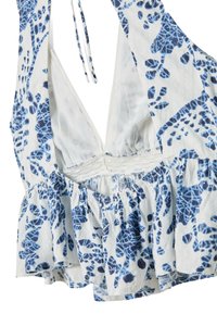Floral-patterned sleeveless top in white and blue; features a deep V-neck, ruffled hem, and textured fabric with a lace trim.