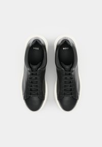 Schwarze Ledersneaker mit weißen Gummisohlen, runder Zehenpartie, flachen Schnürsenkeln und einem dezenten Logo auf der Lasche.