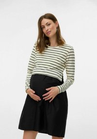 Maternitātes kleita ar melnu svārku un krēmkrāsas svītrainu garām piedurknēm; iezīmēta ar pieguļošu siluetu un saplacinājumu jostasvietā.