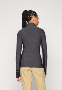 Dark gray zip-up athletic jacket with a textured finish, featuring contrasting black side panels and thumbhole cuffs.