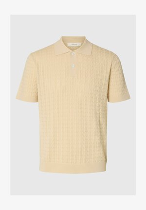 Polo de punto beige de manga corta con patrón de cable texturizado y dos botones blancos en la tapeta, puños y dobladillo acanalados.